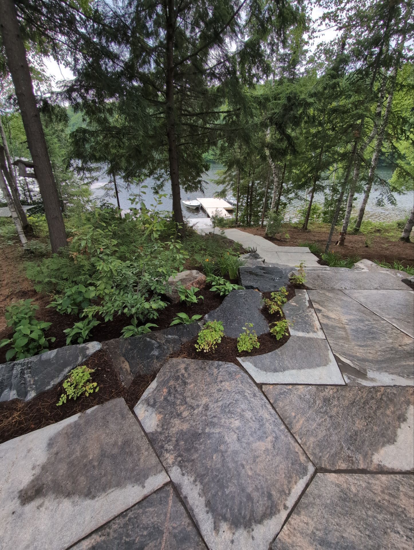 Stone pathway leading to lakeside dock view.