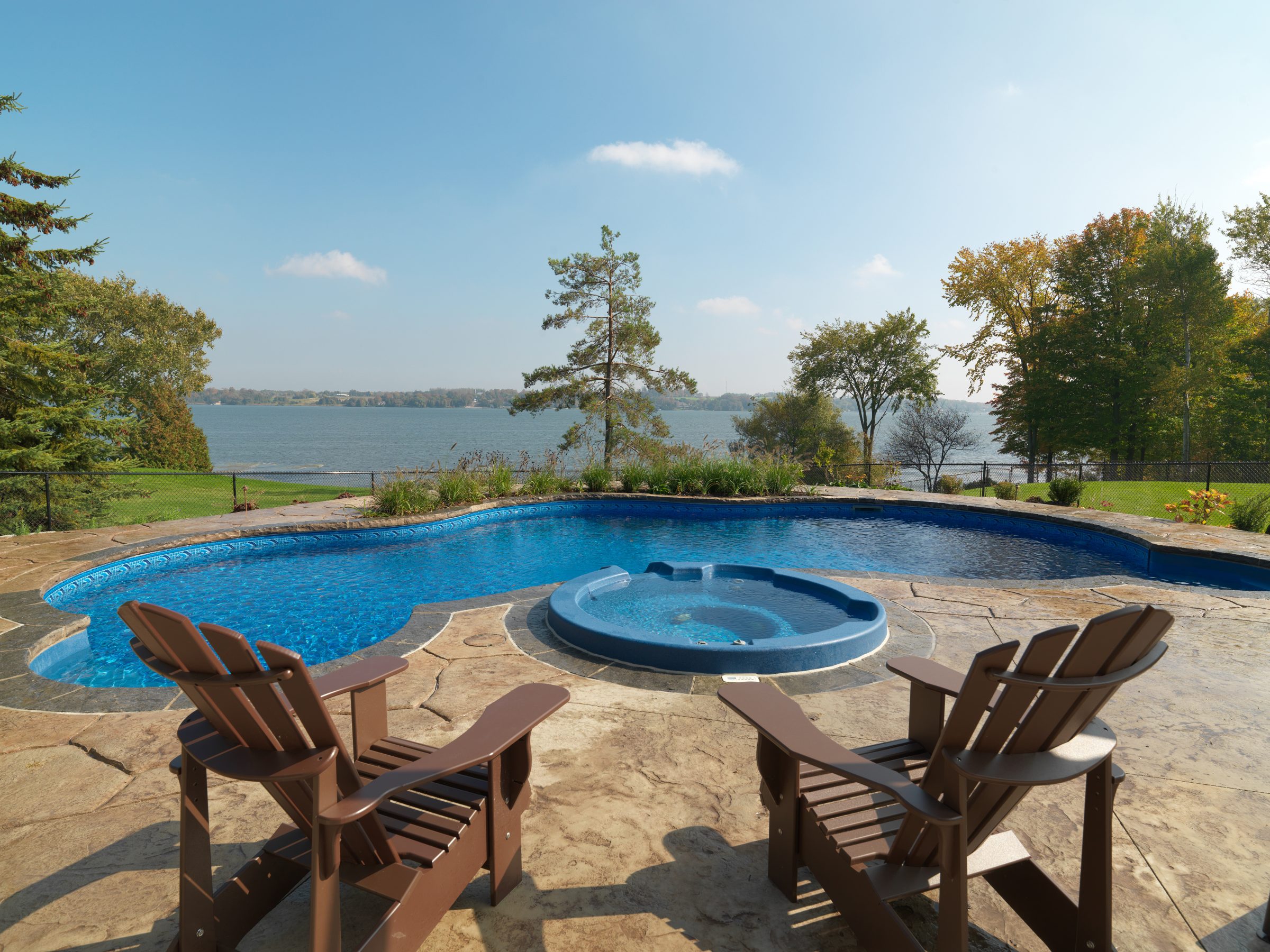 Lakeside pool with chairs and scenic view
