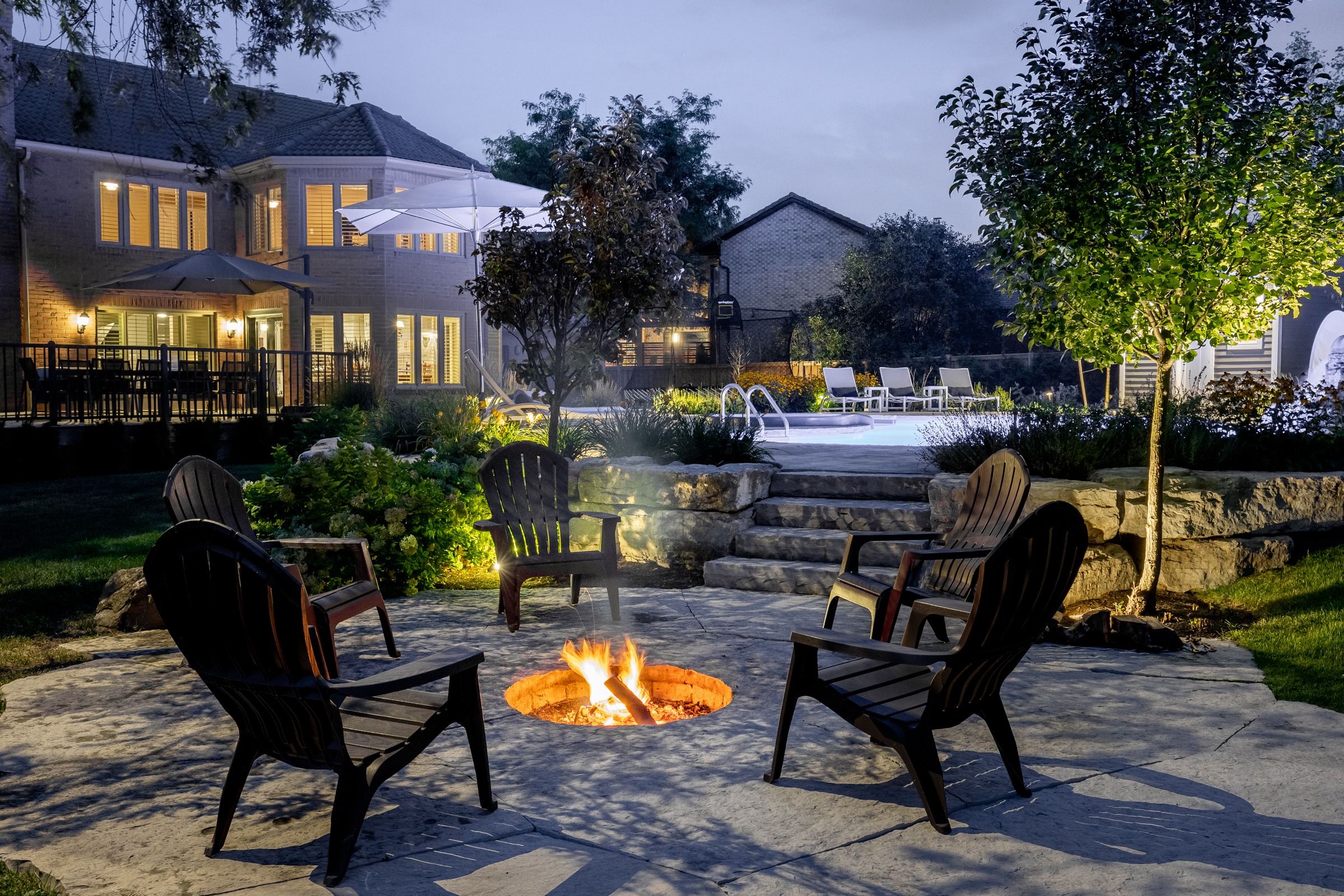 Backyard fire pit and pool area at night