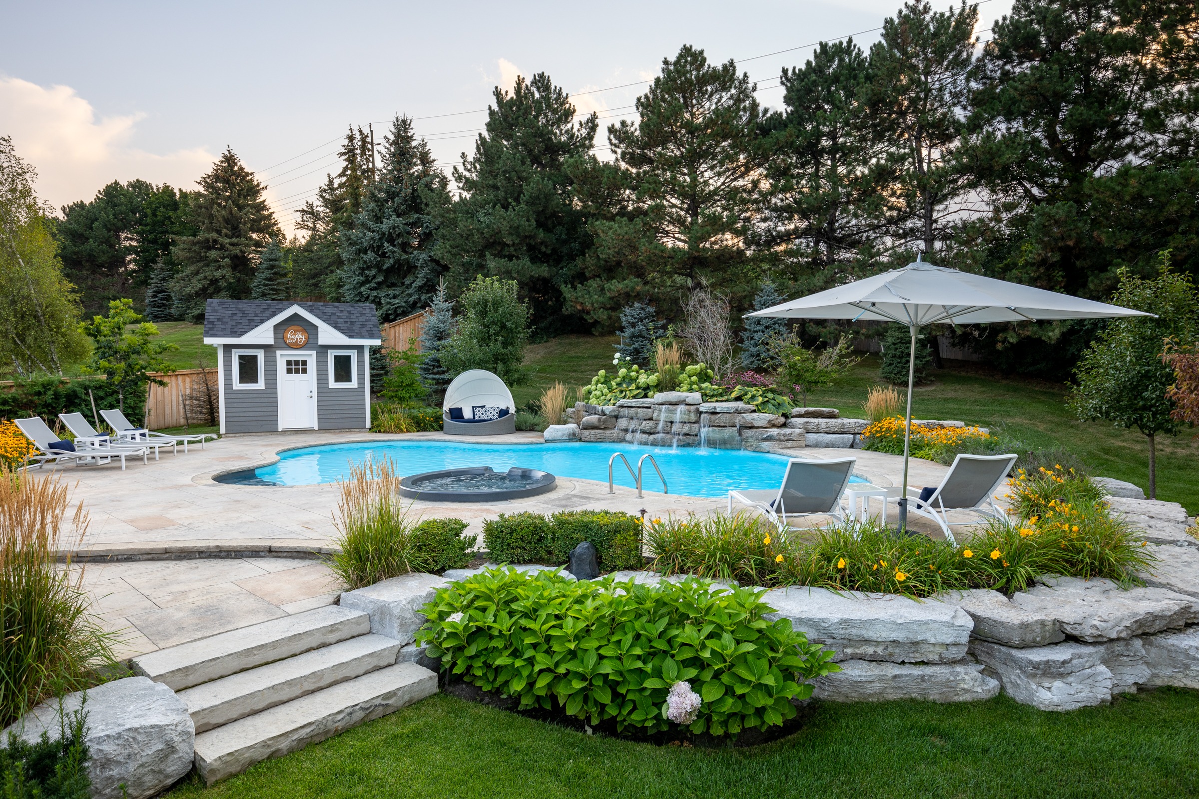 Backyard pool with loungers and garden landscaping.