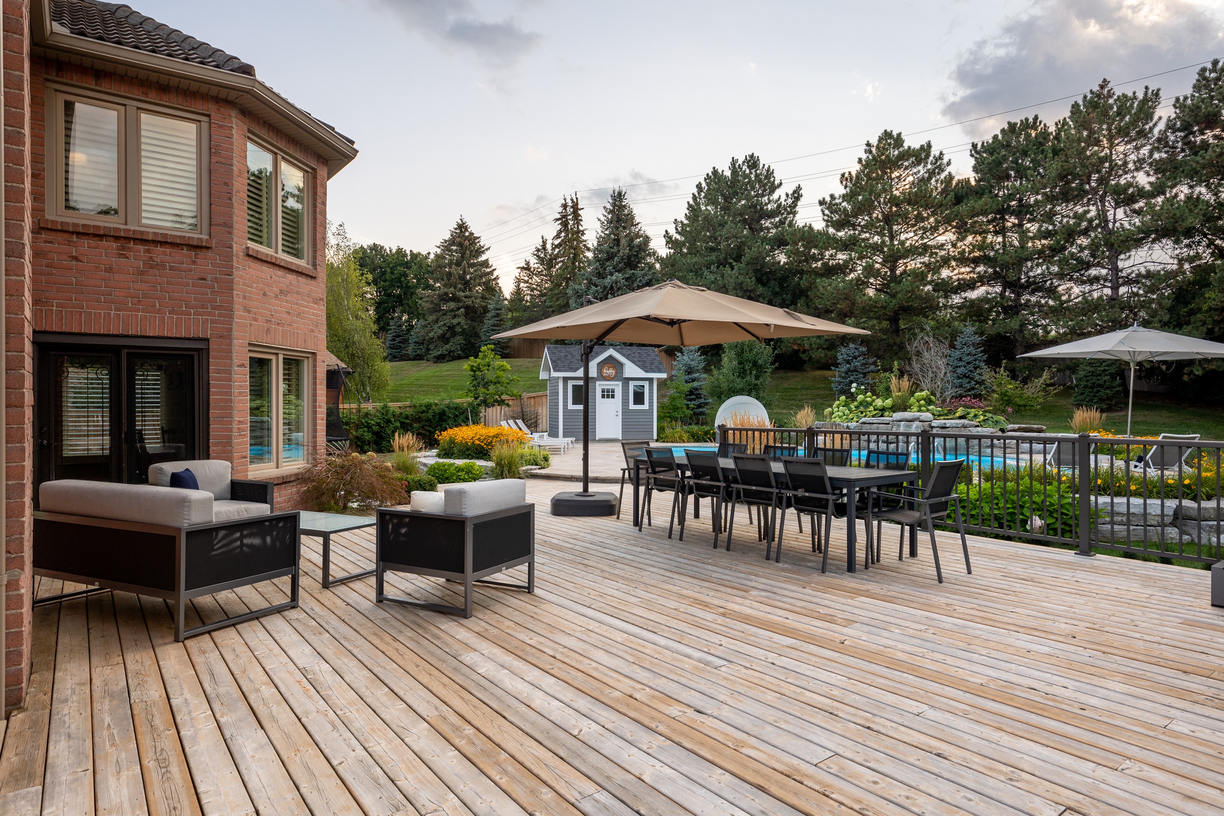 Spacious backyard deck with seating and umbrellas.