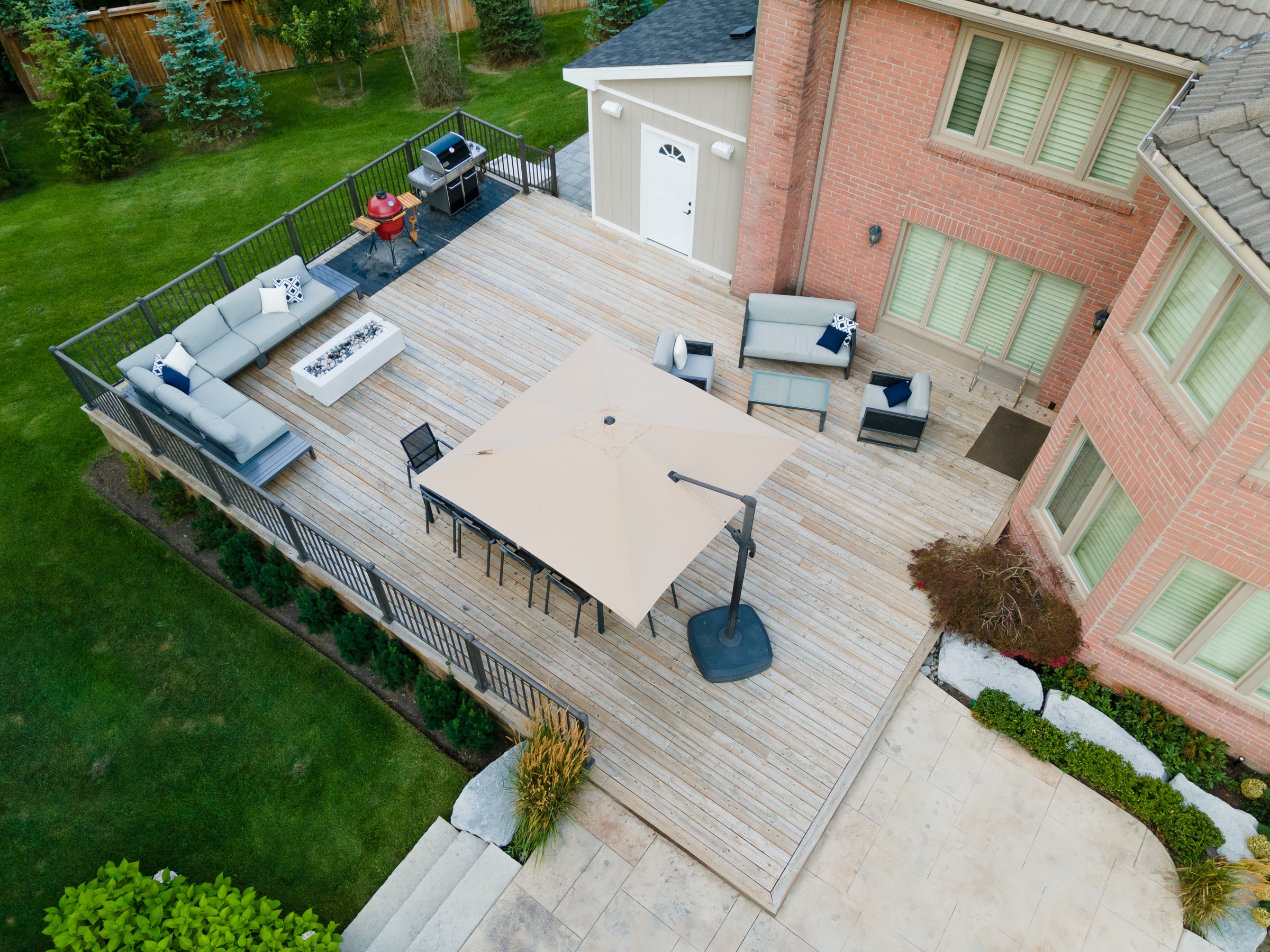 Spacious wooden deck with seating and grill area.