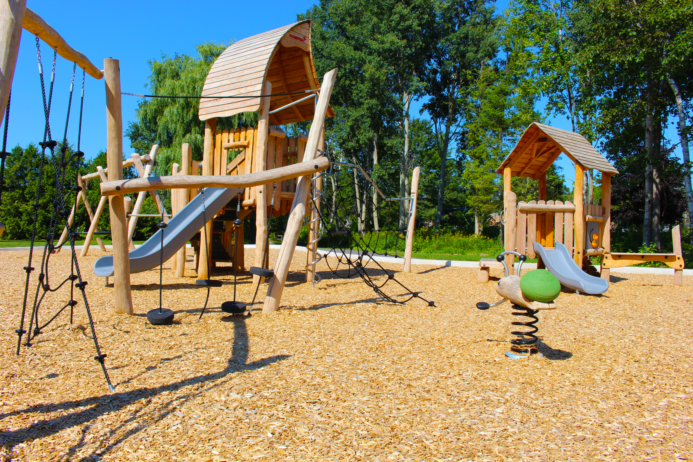 Wooden playground with slides and climbing structures.