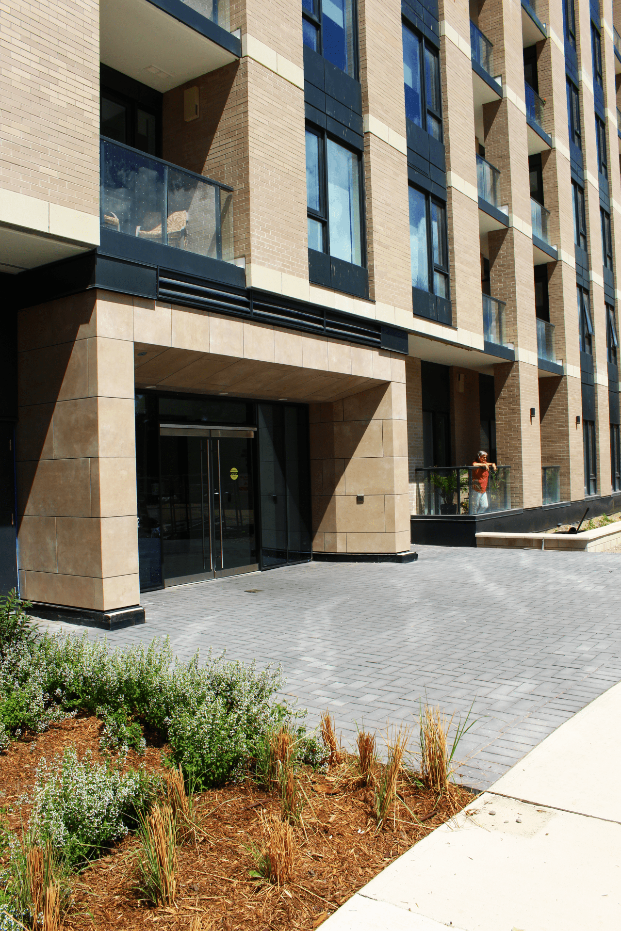 Modern building entrance with balcony and plants