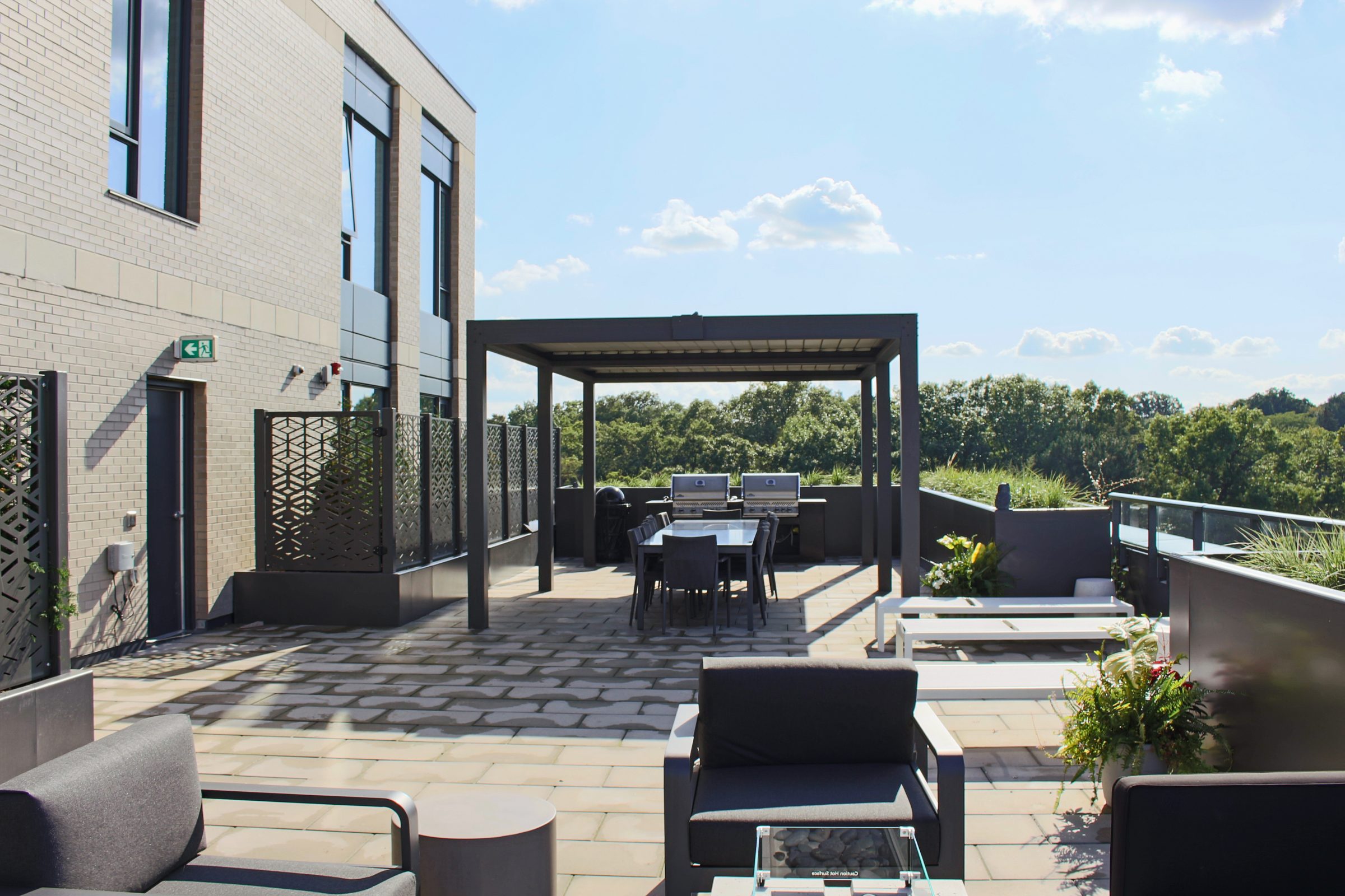 Modern rooftop terrace with outdoor seating and tables.
