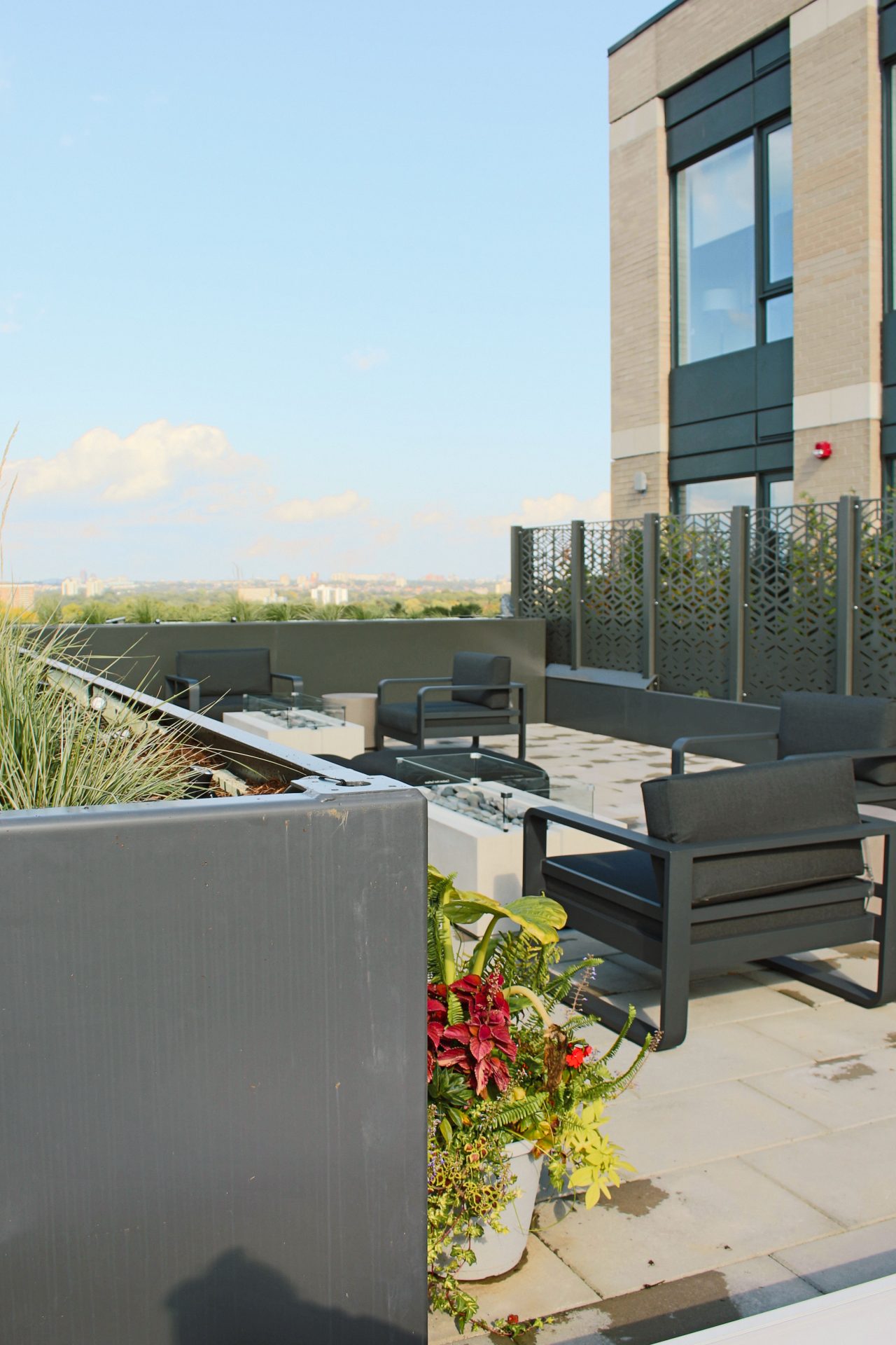 Modern rooftop patio with city view and seating.