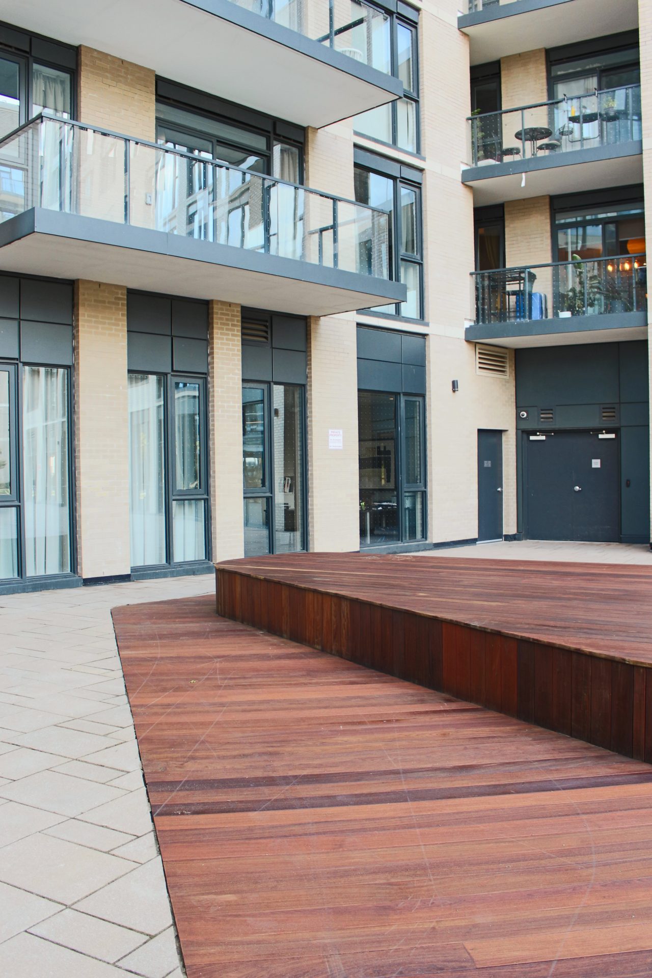 Modern apartment building with wooden platform.