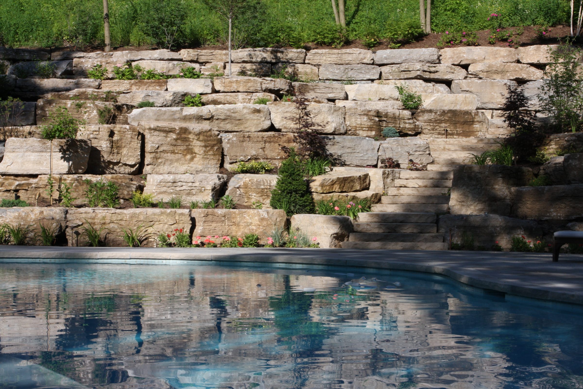 Stone wall and pool in landscaped garden