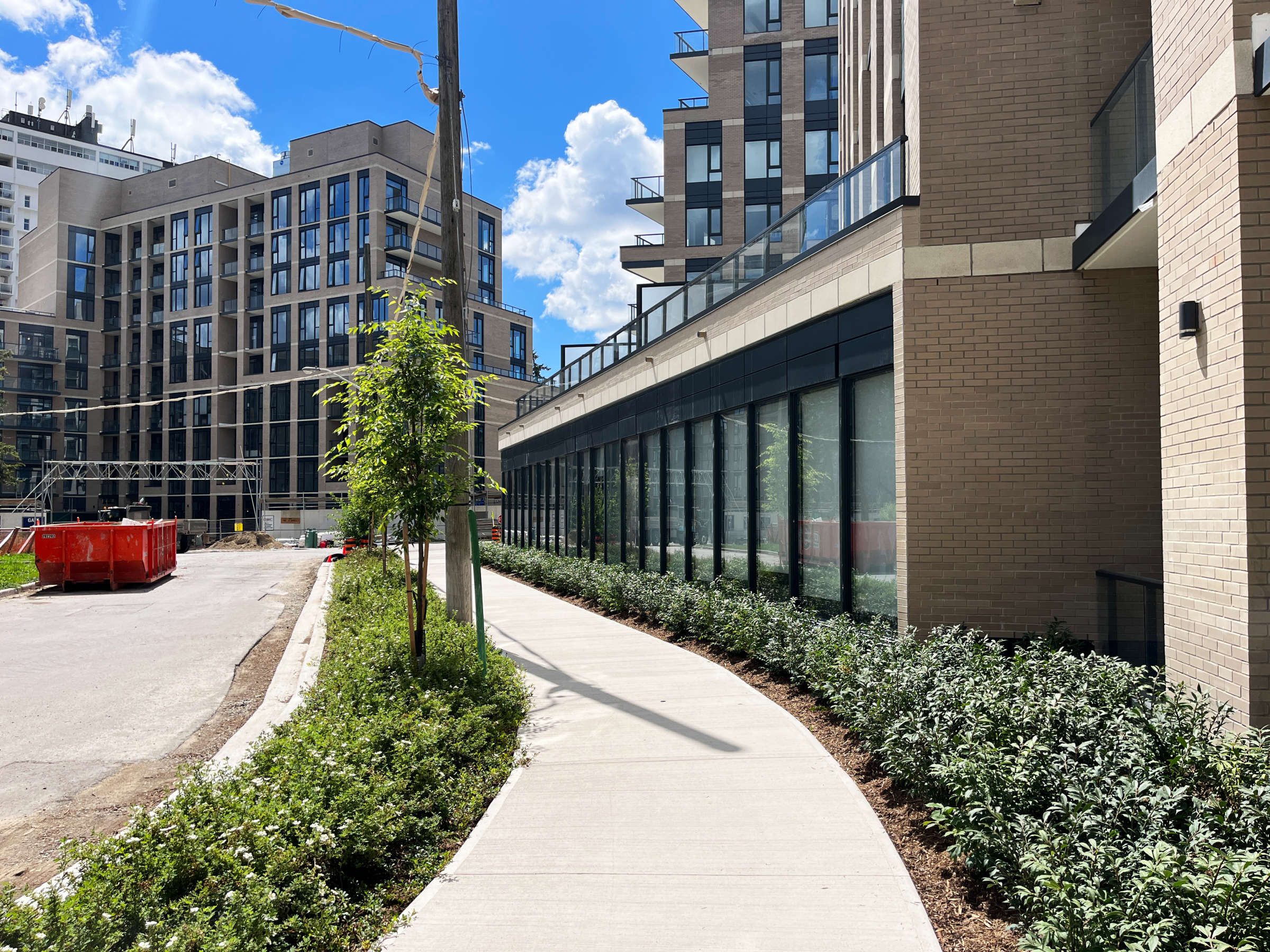 Modern urban buildings with sunny walkway path