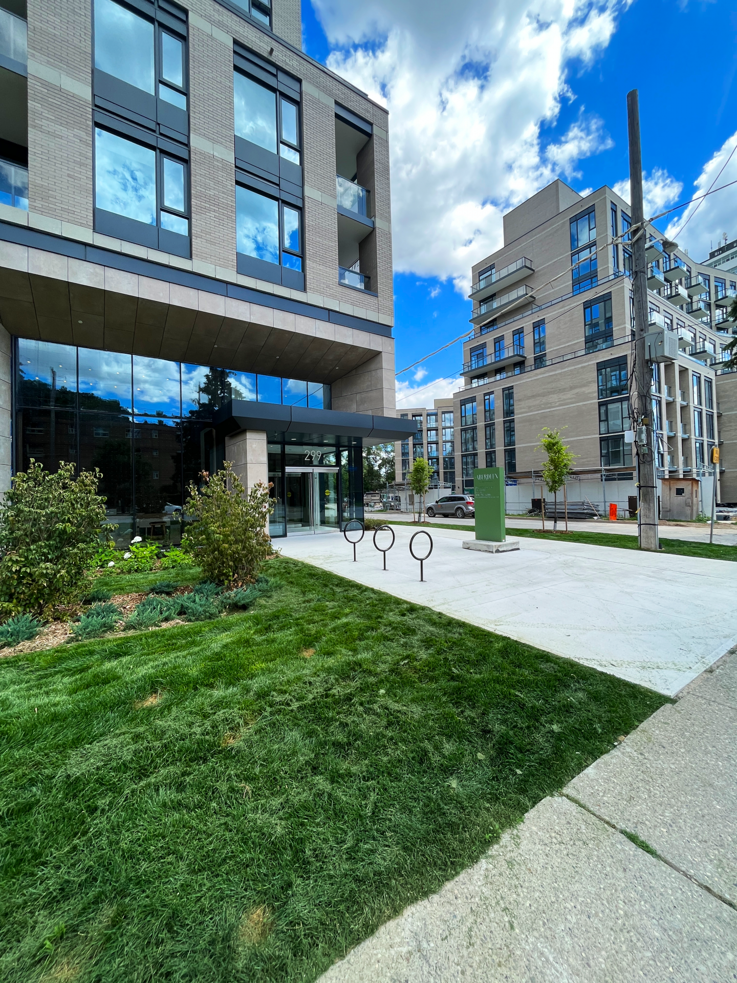 Modern apartment building with green lawn and blue sky.