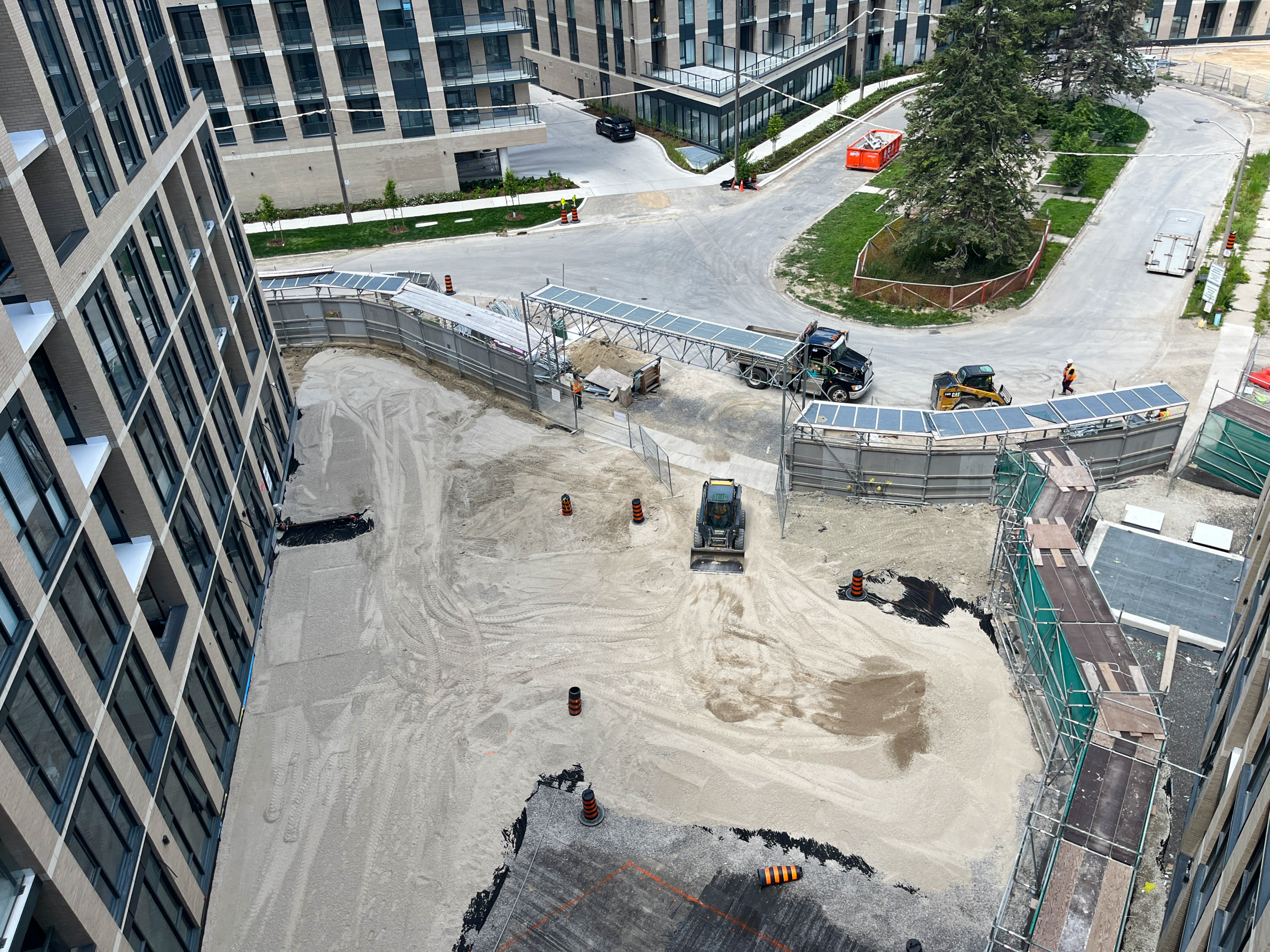 Construction site with machinery and safety barriers.