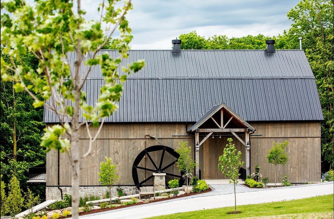 Rustic barn with waterwheel and lush greenery