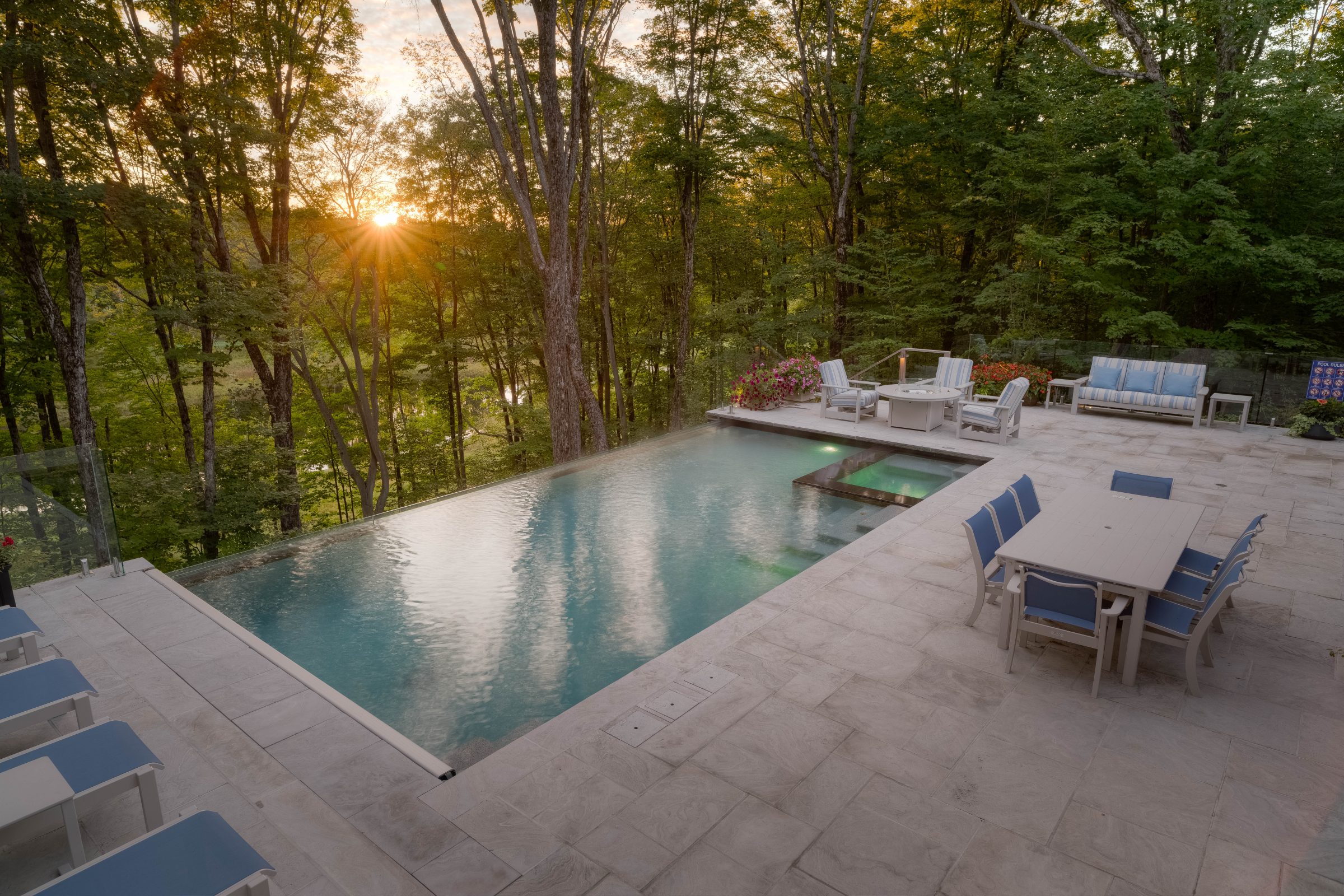 Sunset over pool and patio in forest.