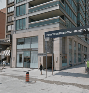 Urban street corner with residential building and shops.