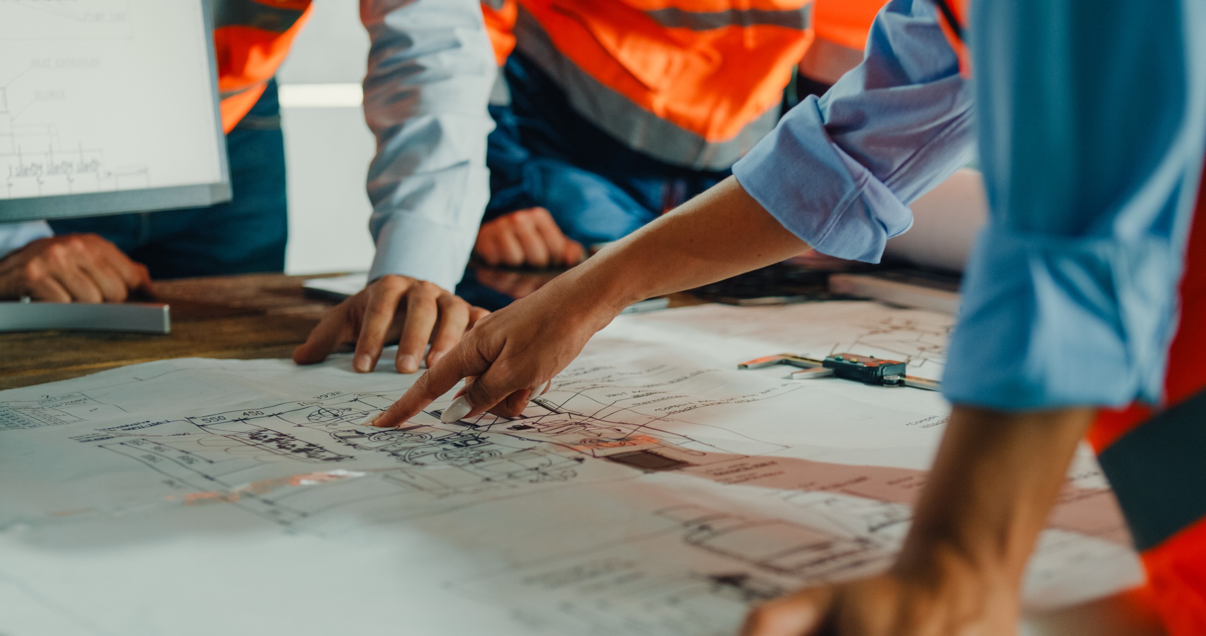 Group discussing architectural plans on a table.