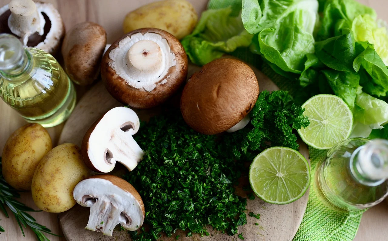 Fresh ingredients: mushrooms, potatoes, lime, lettuce, and herbs.