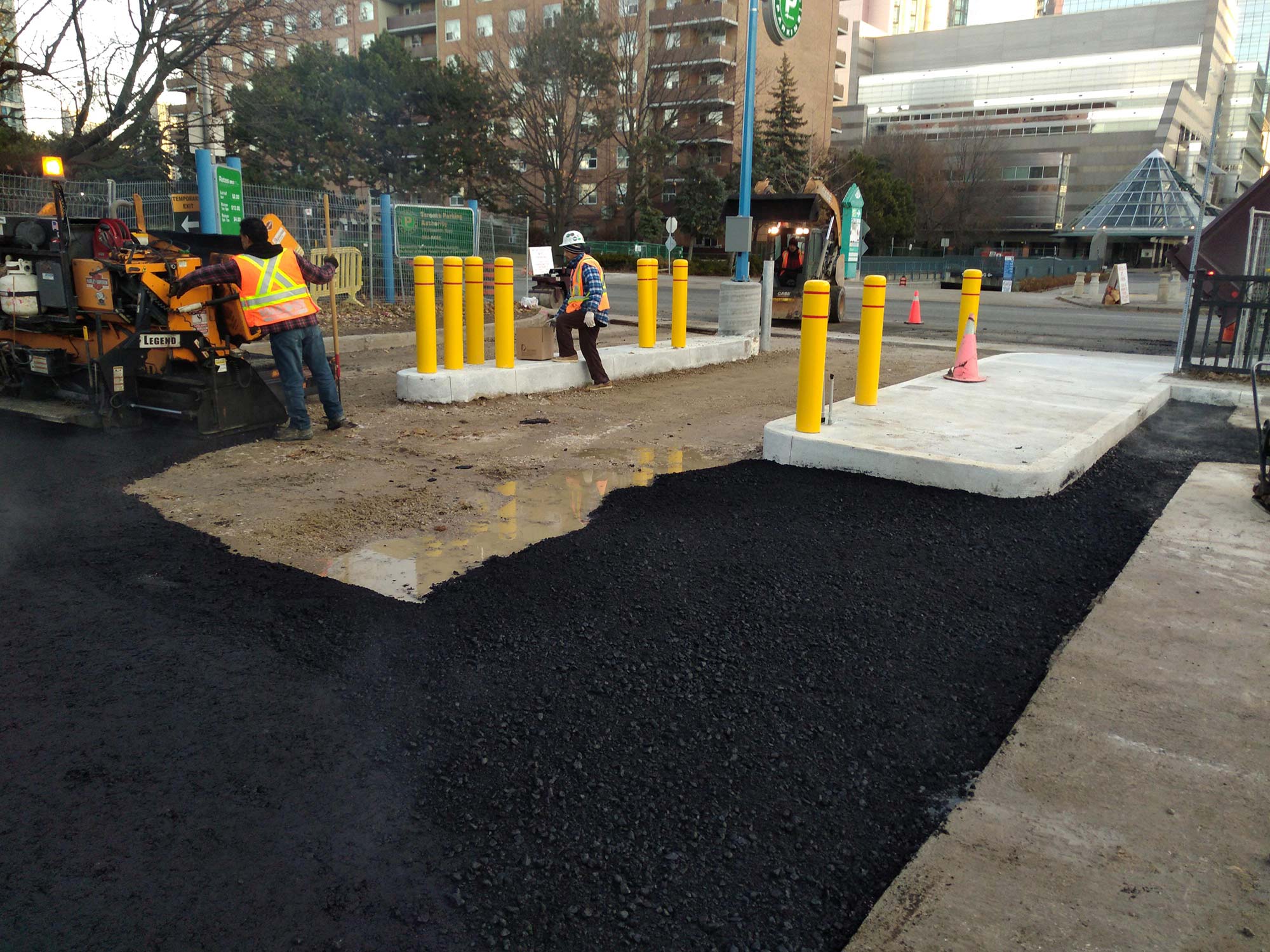 Workers paving road in urban construction site.