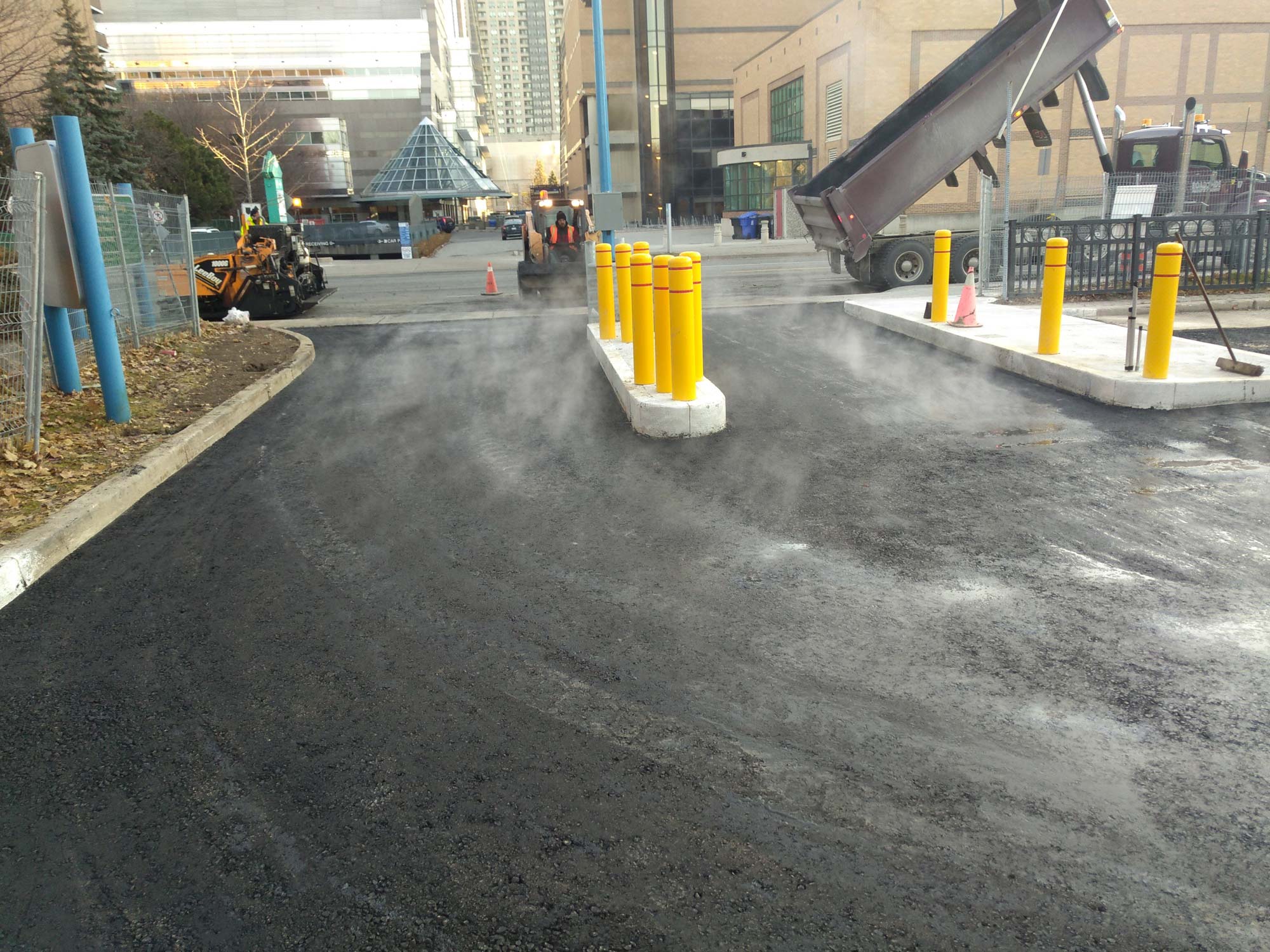 Freshly paved city street with steam rising.