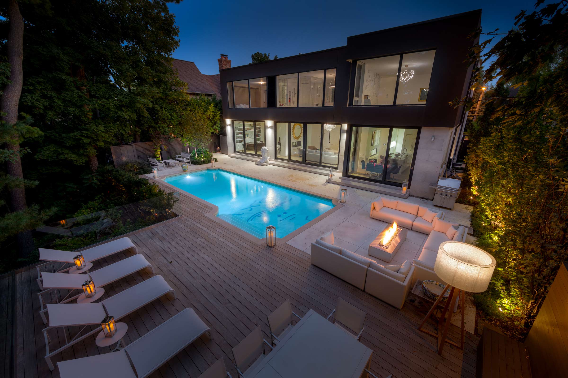Modern house with pool and outdoor seating at night.