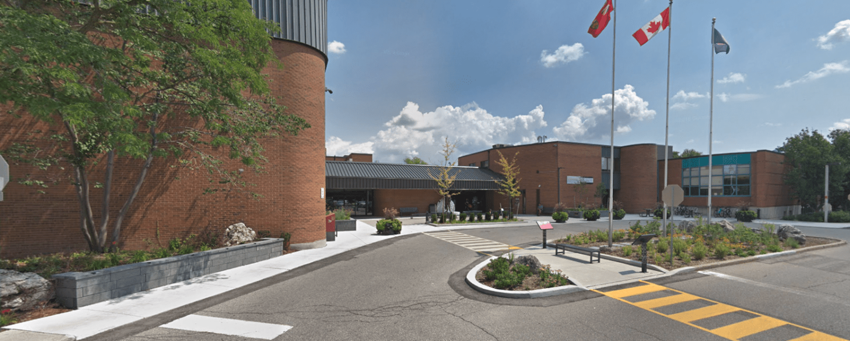 Brick building with three flags outside.
