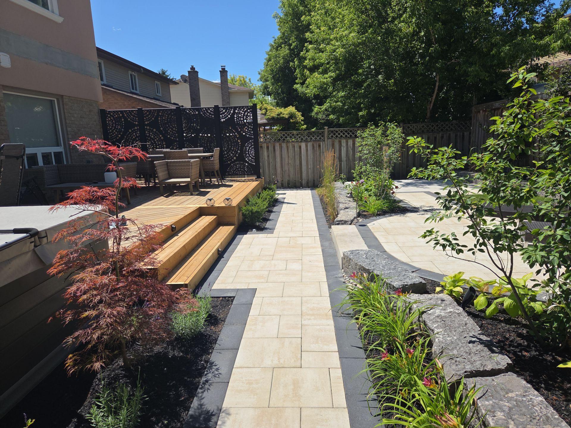 Backyard patio with wood deck, steps, and garden beds