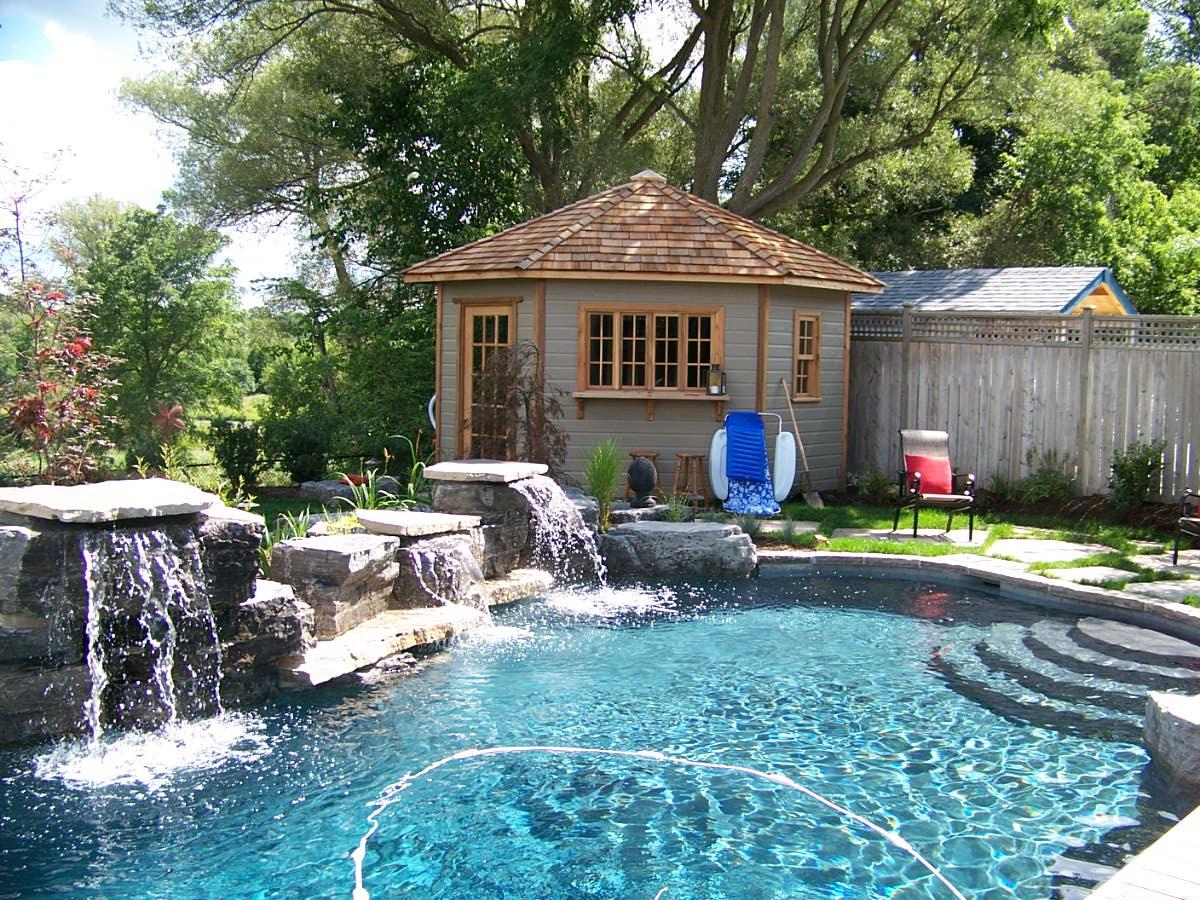 Backyard pool with waterfall and garden shed