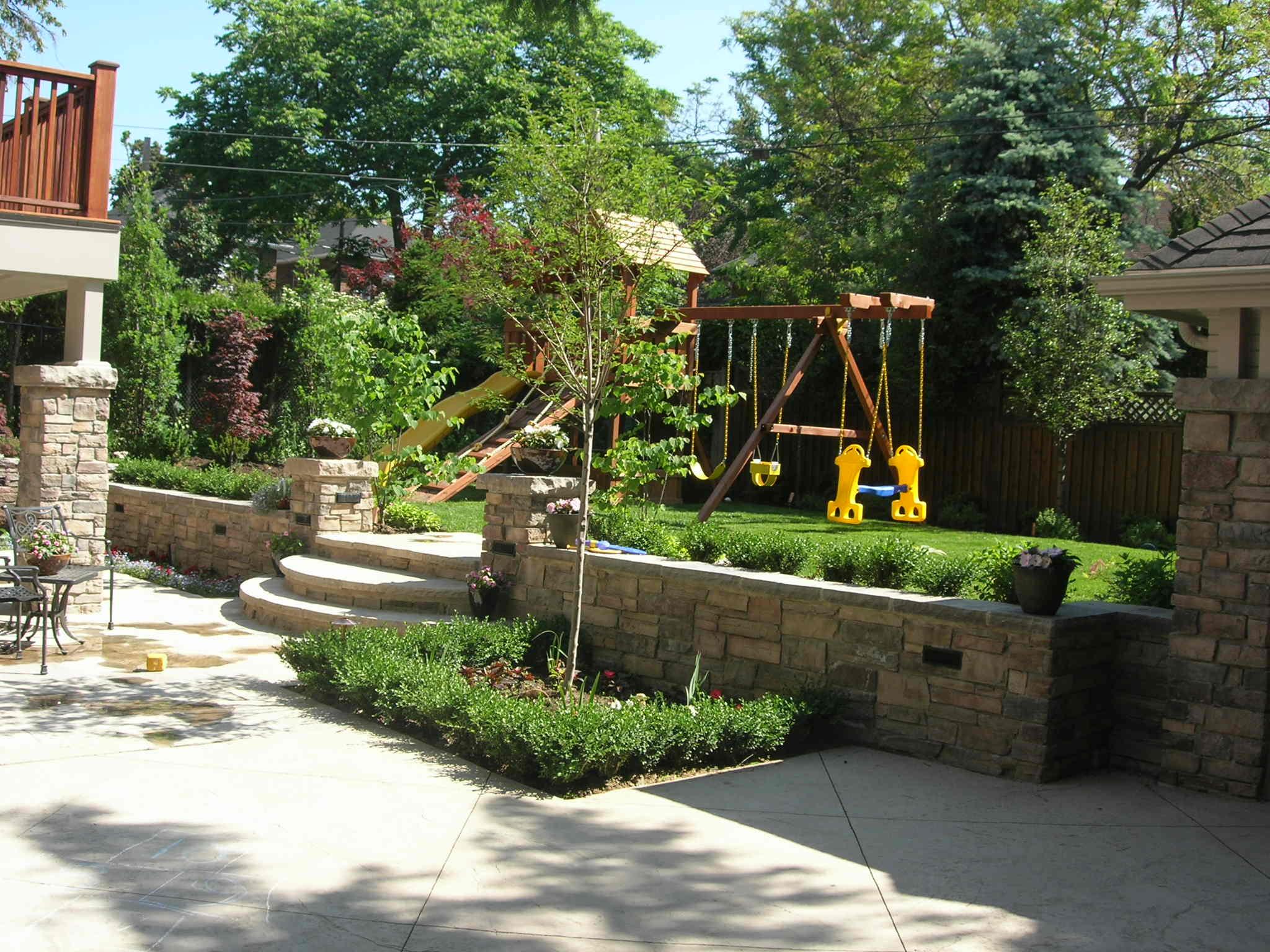 Backyard with raised stone wall and children’s play area