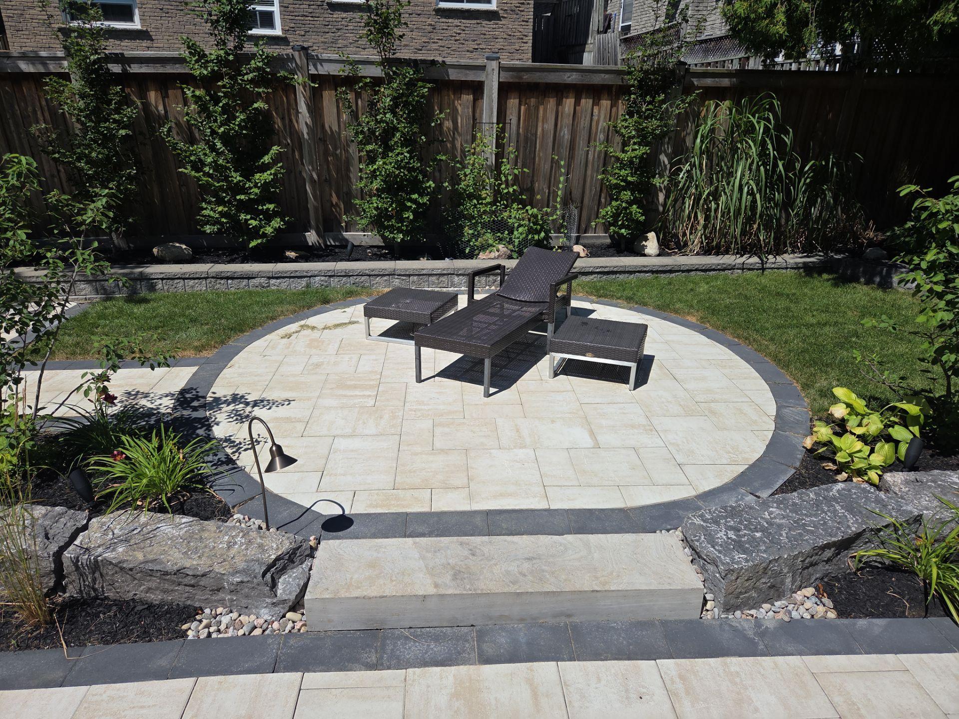 Circular patio with lounge chairs and landscaped yard
