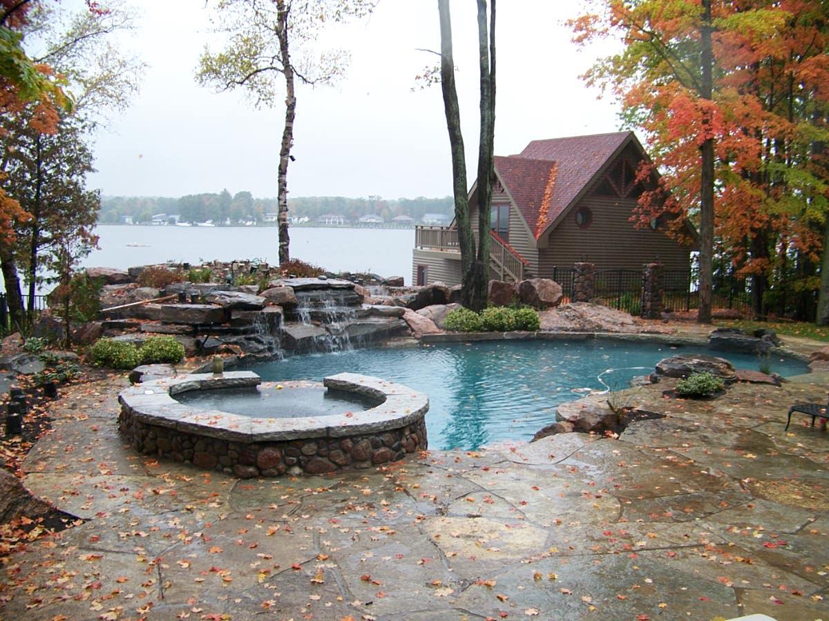 Natural stone pool with waterfall by lakeside