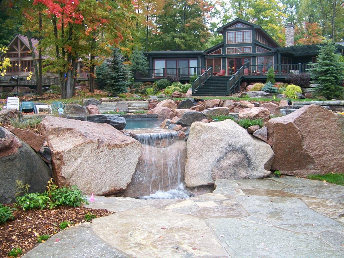Natural stone waterfall feature in backyard landscape
