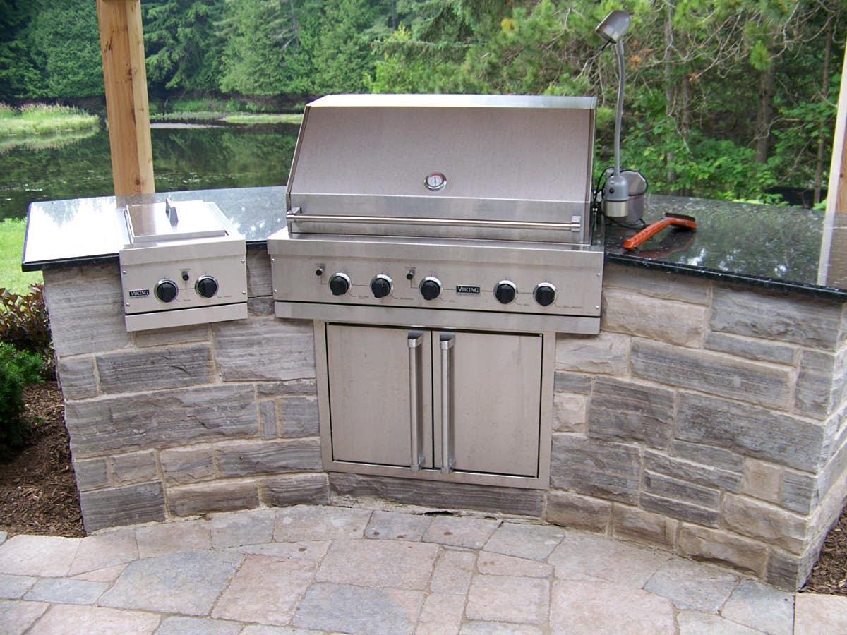 Outdoor kitchen with built-in grill and stone base