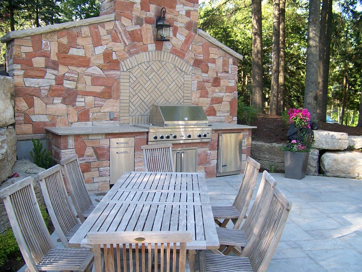Outdoor kitchen with stone wall and dining area
