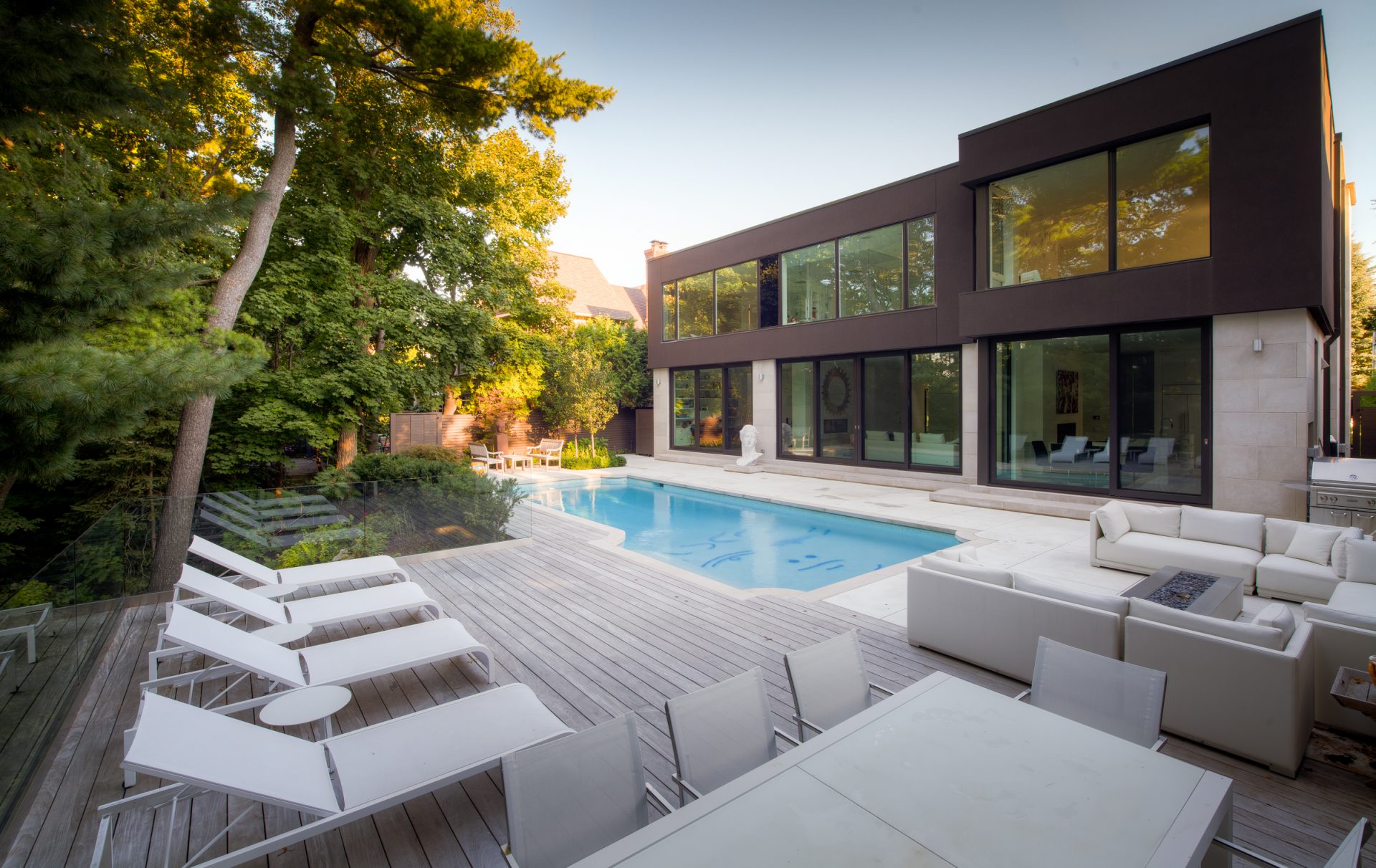 Modern house with pool and patio seating area.